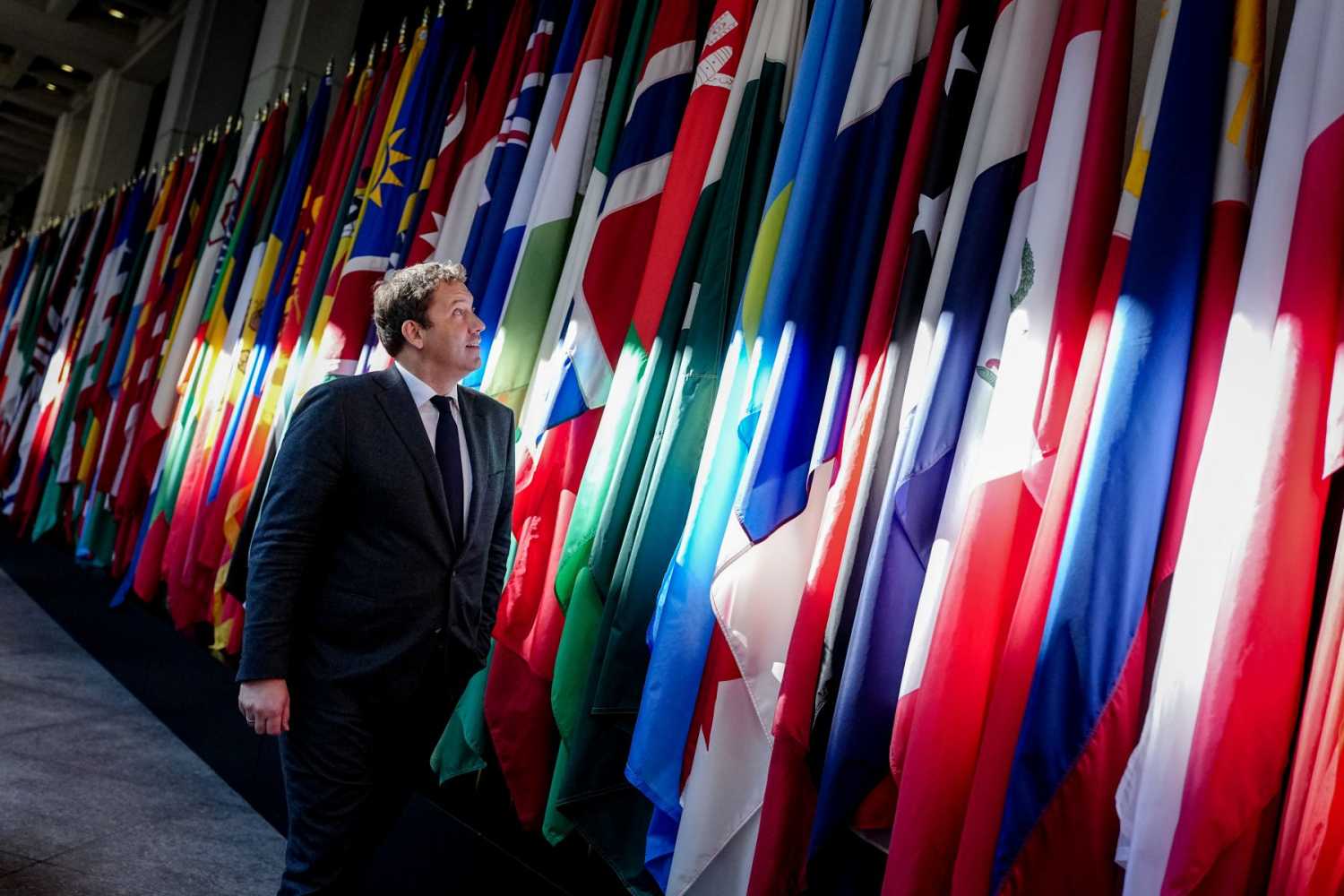 A man walks past country flags