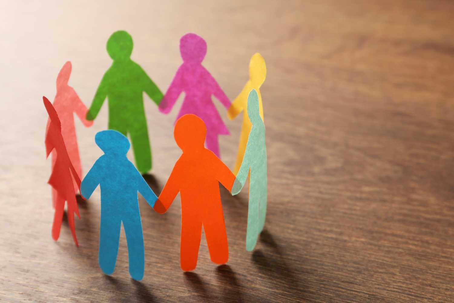 Paper cutouts of people hold hands in a circle