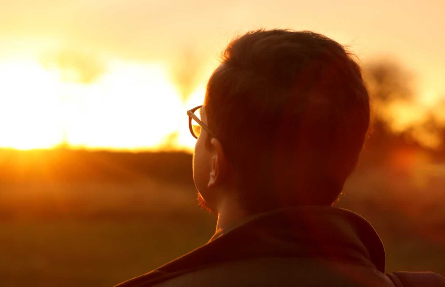 Man looking into sunset.