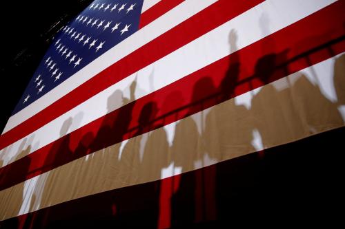The shadows of supporters of U.S. President Donald Trump are seen on an American Flag at a campaign rally in Las Vegas, Nevada, U.S., September 20, 2018.