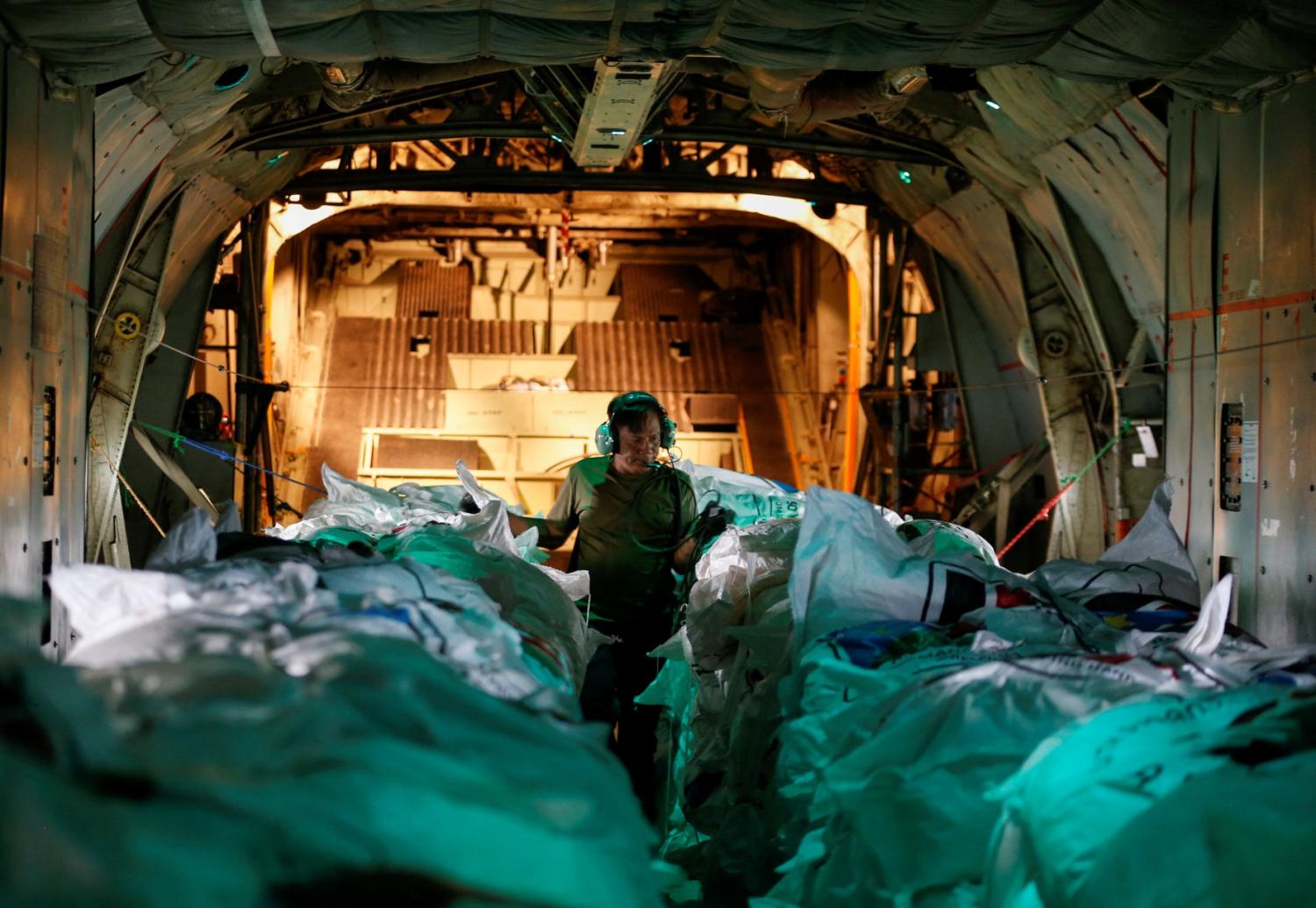 A worker prepares to release food aid from a cargo plane within Nasir town airspace, ravaged by fighting between local militiamen and the army, in an operation run by Fogbow, a U.S. company organising the airdrops with funding from the South Sudanese government, in Nasir County of Upper Nile State, South Sudan June 10, 2025.