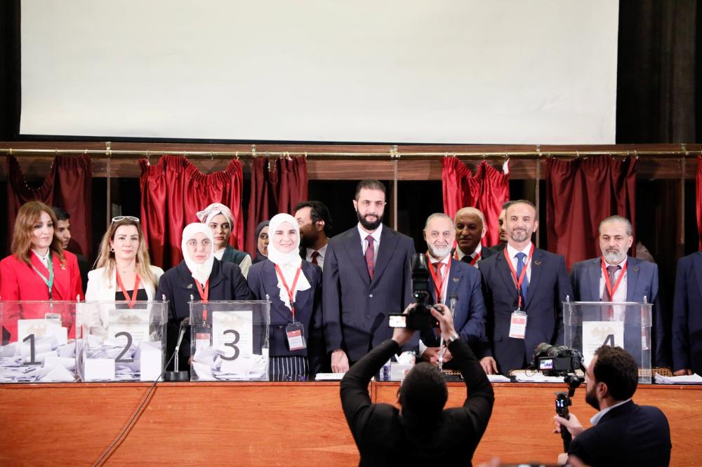 President Ahmad al-Sharaa speaks to voters at a polling station inside the National Library during Syria's first parliamentary elections since the fall of the Assad regime, October 5, 2025.