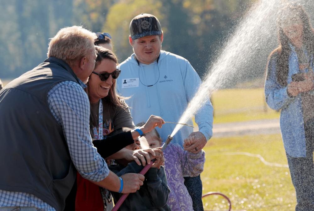 Myrtlewood Elementary special education teacher Shea Cork helps her students water plants alongside Greer Willians during a hands-on visit to the Tuscaloosa County School System K-12 Ag Farm on Nov. 6, 2025, in Tuscaloosa, Alabama.