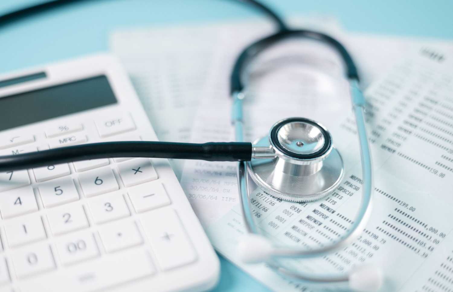 Calculator and stethoscope on accounting documents.