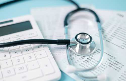 Calculator and stethoscope on accounting documents.