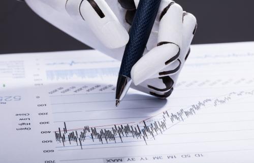 Robot hand holding pen evaluating financial chart