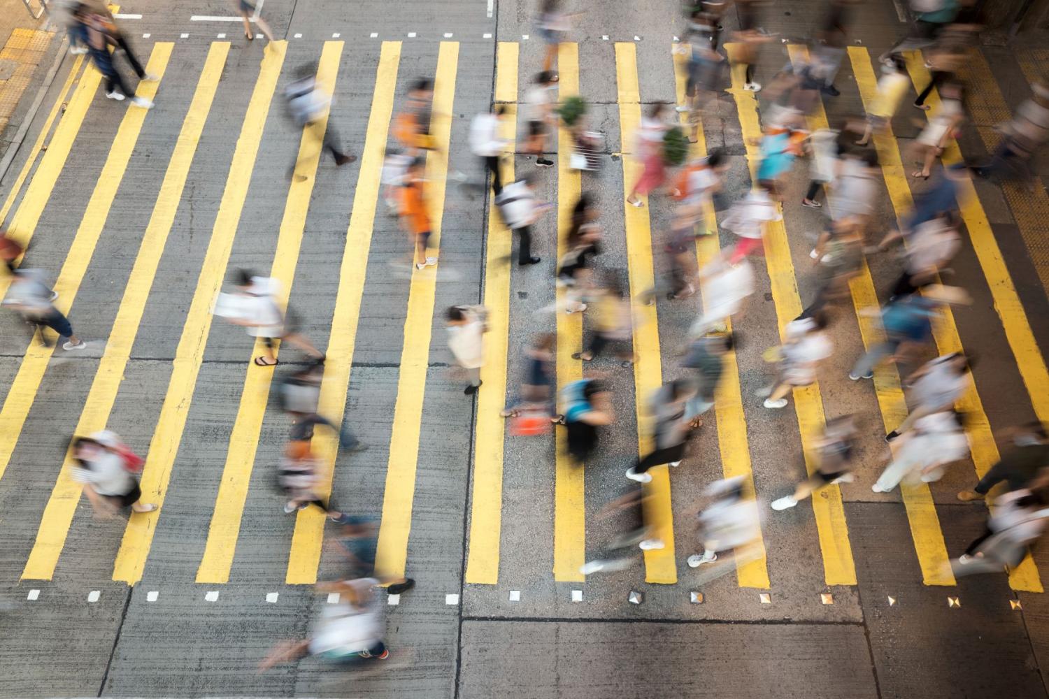 A crowd of people crossing at a crosswalk