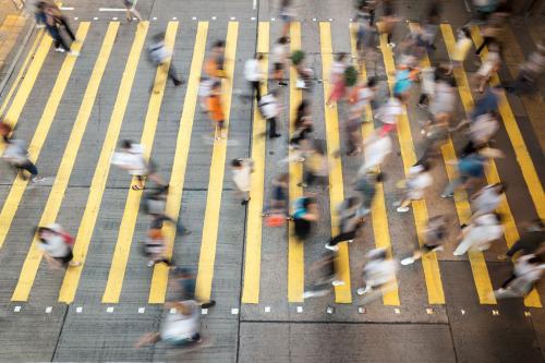 A crowd of people crossing at a crosswalk