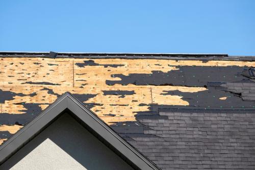 Damaged house roof with missing shingles after hurricane Ian in Florida. Consequences of natural disaster