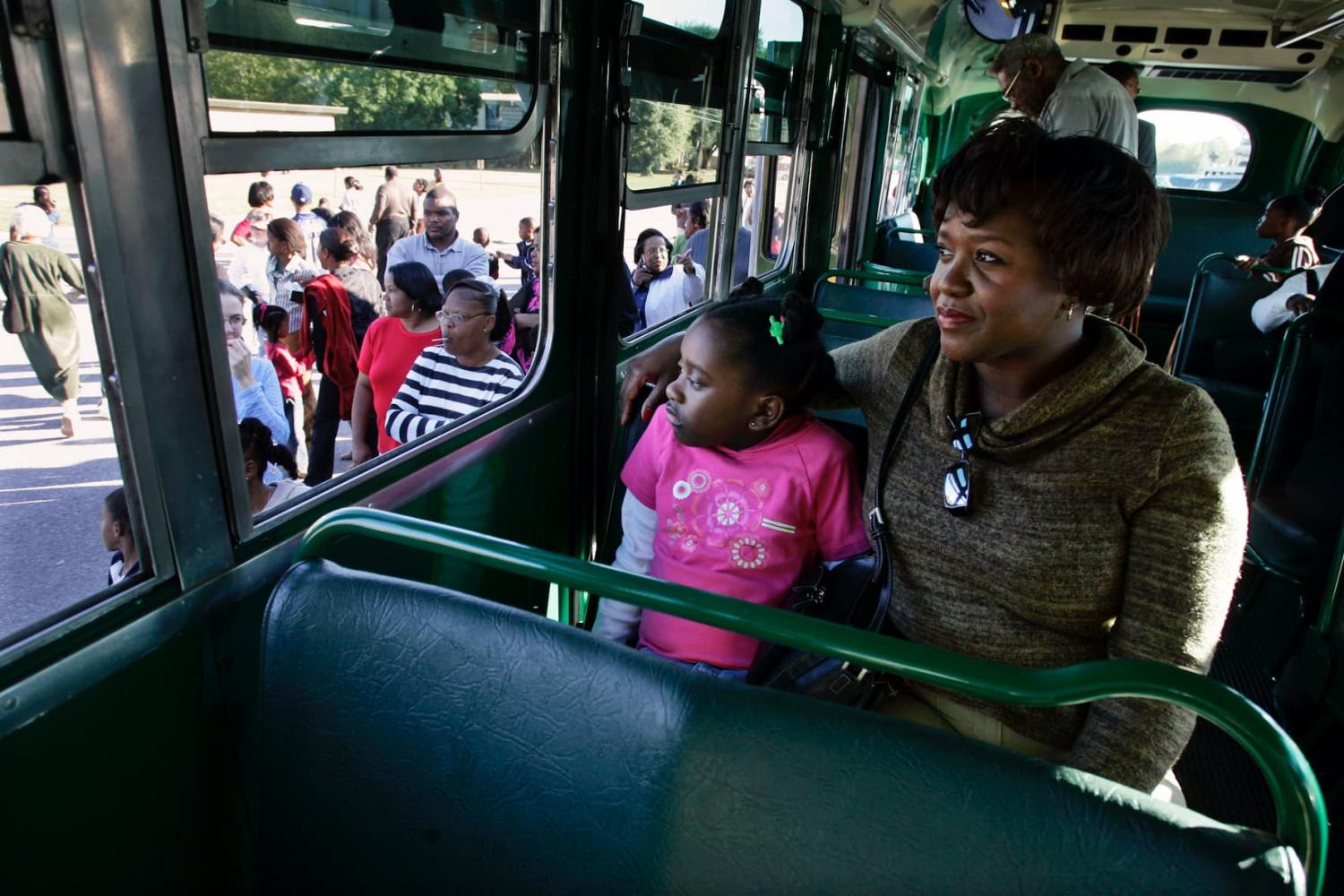 Sheila Watkins (right) and her daughter ride a restored Montgomery bus from the Rosa Parks Museum—the same model Parks rode—after paying their respects at St. Paul African Methodist Episcopal Church in Montgomery, Alabama, on Oct. 29, 2005.