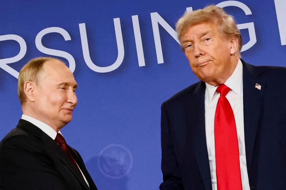 U.S. President Donald Trump looks on next to Russian President Vladimir Putin during a press conference following their meeting to negotiate an end to the war in Ukraine, at Joint Base Elmendorf-Richardson, in Anchorage, Alaska, U.S., August 15, 2025.