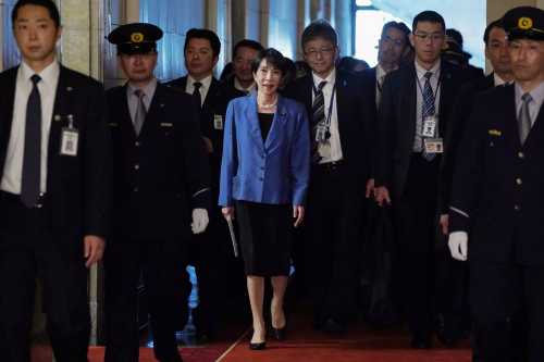 Japan's Prime Minister Sanae Takaichi (C) arrives for a debate with opposition party leaders in the National Diet in Tokyo on November 26, 2025.
