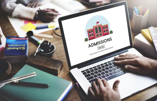 Person typing on a laptop with an Admissions page.