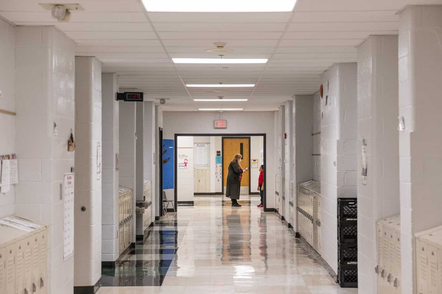 A teacher speaks with one of her students outside of a classroom in a hallway at Carter Traditional Elementary School on Jan. 24, 2022, in Louisville, Kentucky.