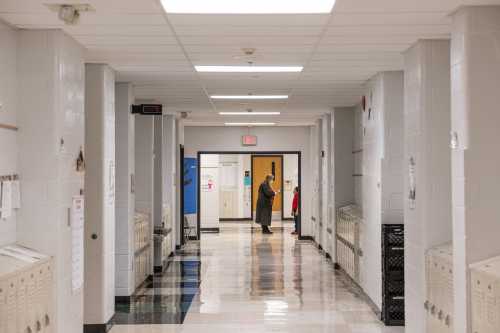 A teacher speaks with one of her students outside of a classroom in a hallway at Carter Traditional Elementary School on Jan. 24, 2022, in Louisville, Kentucky.