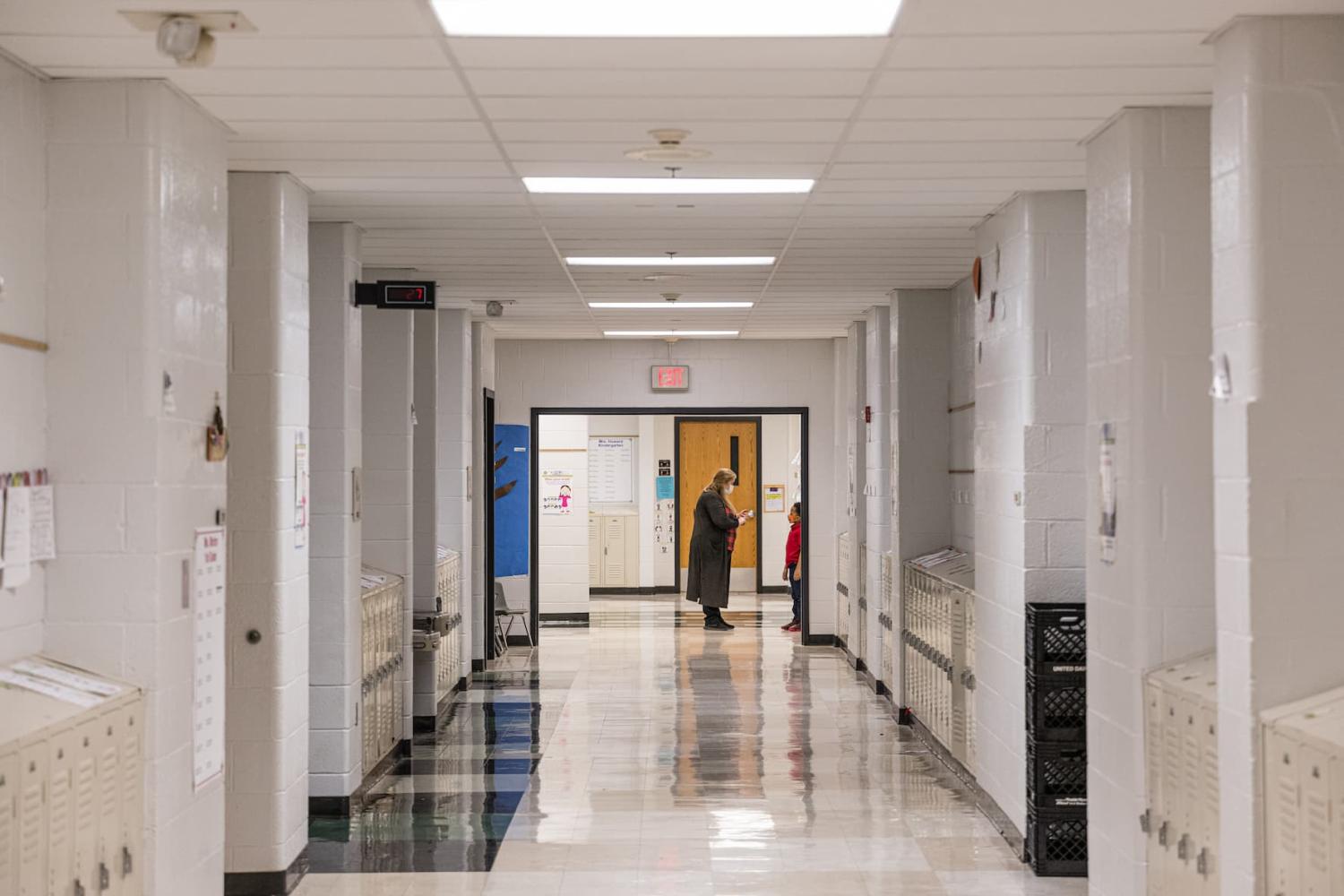A teacher speaks with one of her students outside of a classroom in a hallway at Carter Traditional Elementary School on Jan. 24, 2022, in Louisville, Kentucky.