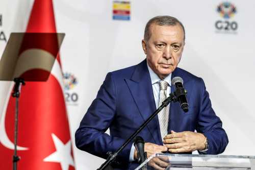 Turkey's President Recep Tayyip Erdogan buttons up his jacket during a press conference after the conclusion of the G20 Leaders' Summit at the Nasrec Expo Centre in Johannesburg on November 23, 2025.