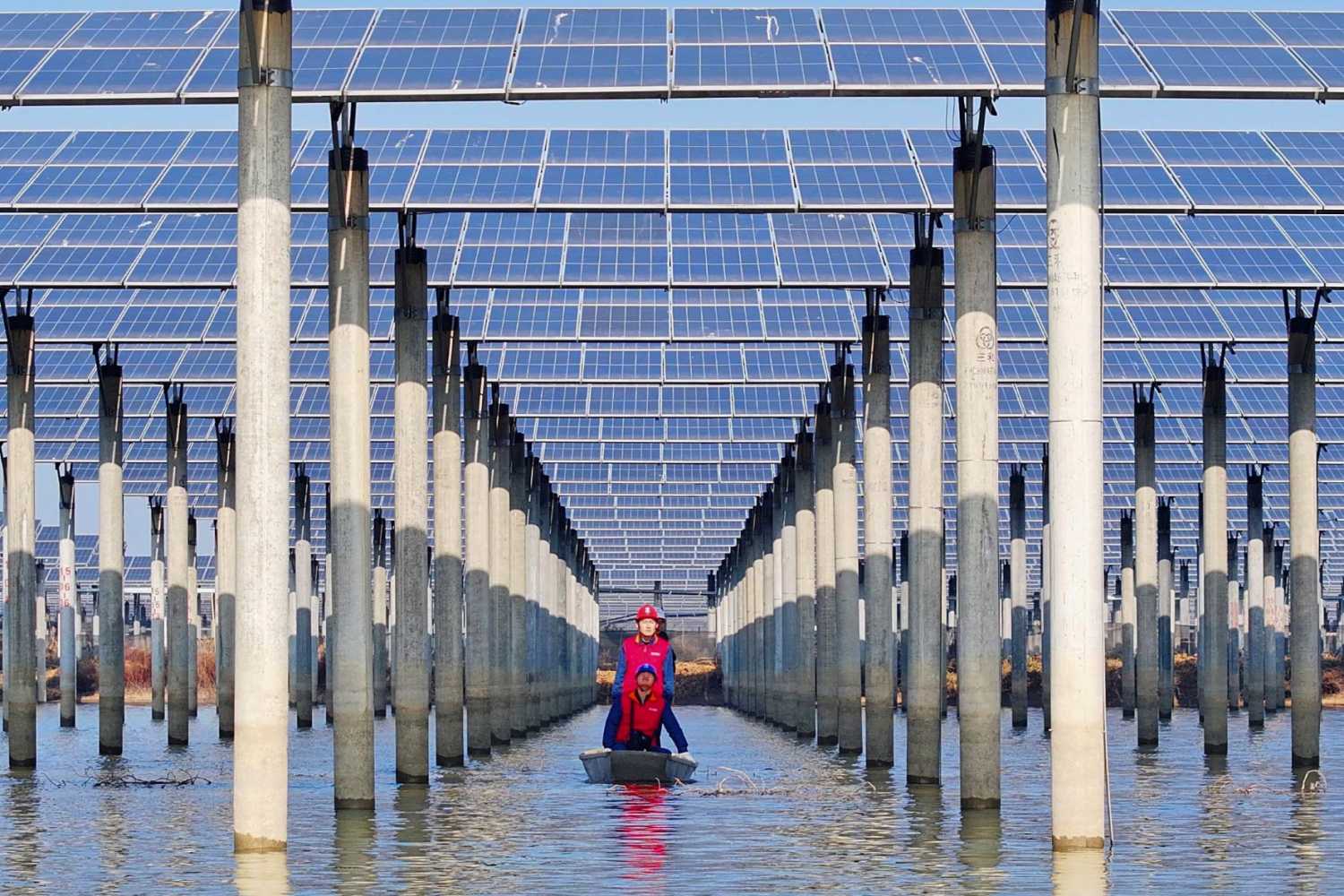 Workers check solar panels installed on a lake in Tianchang, east China's Anhui province on January 12, 2026.