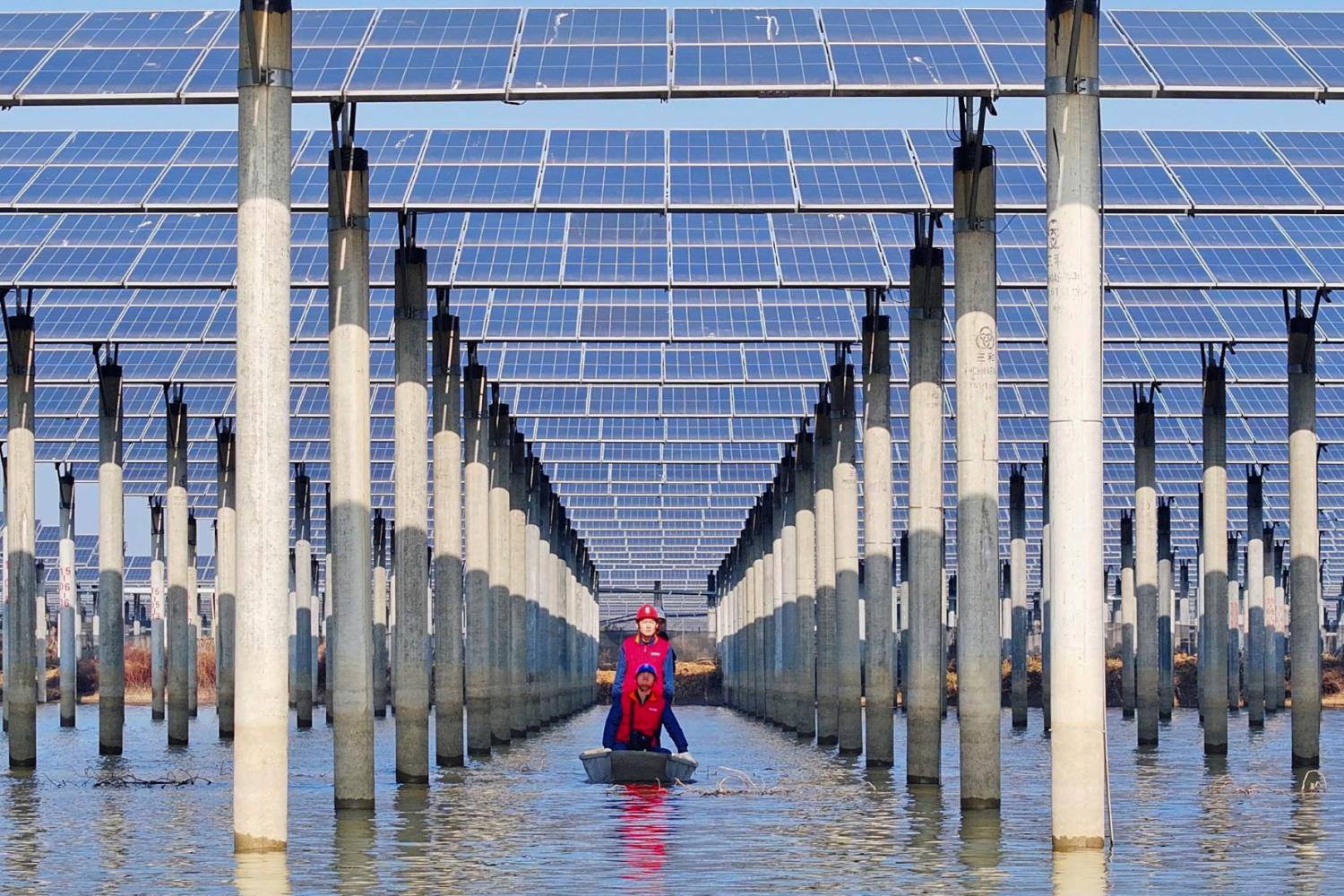 Workers check solar panels installed on a lake in Tianchang, east China's Anhui province on January 12, 2026.