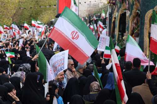 Iranians wave national flags during the funerals of security forces personnel killed in recent protests in Tehran on January 14, 2026.