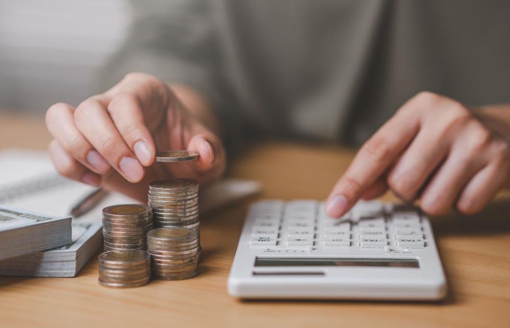 A person using a calculator and organizing coins.