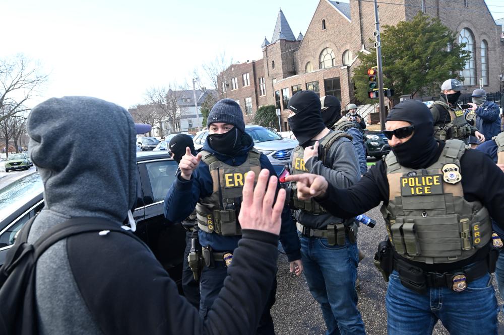 ICE agents confront an observer on January 13, 2026, in Minneapolis, Minnesota