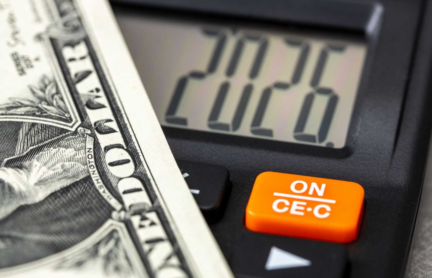 A calculator reading 2026 with a dollar bill.