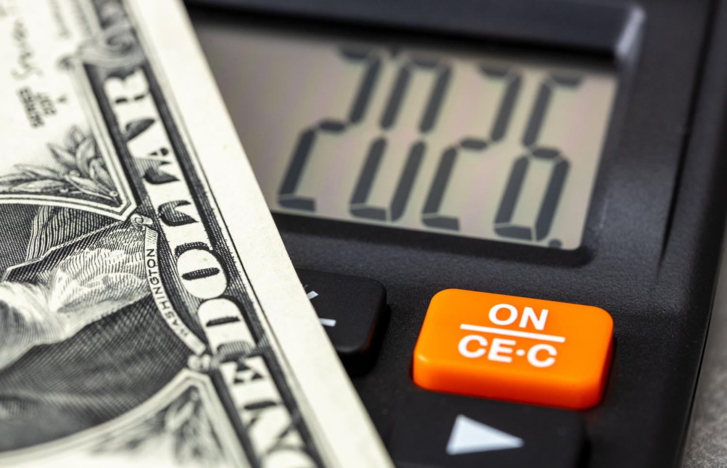 A calculator reading 2026 with a dollar bill.