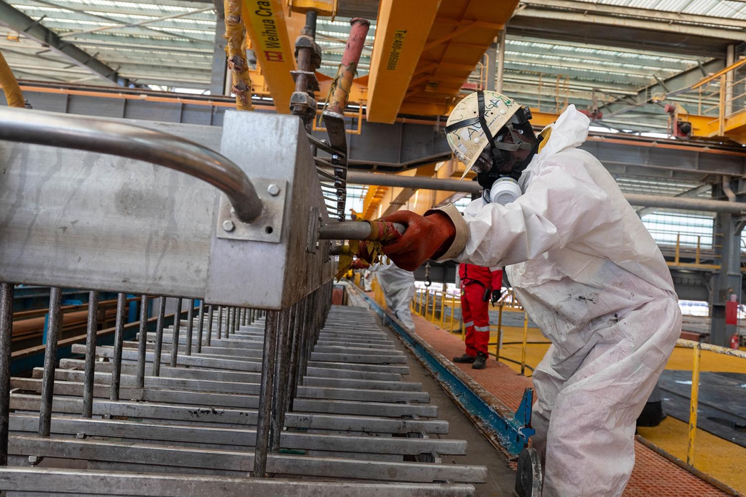A worker wears protection gear in a mineral processing facitlity