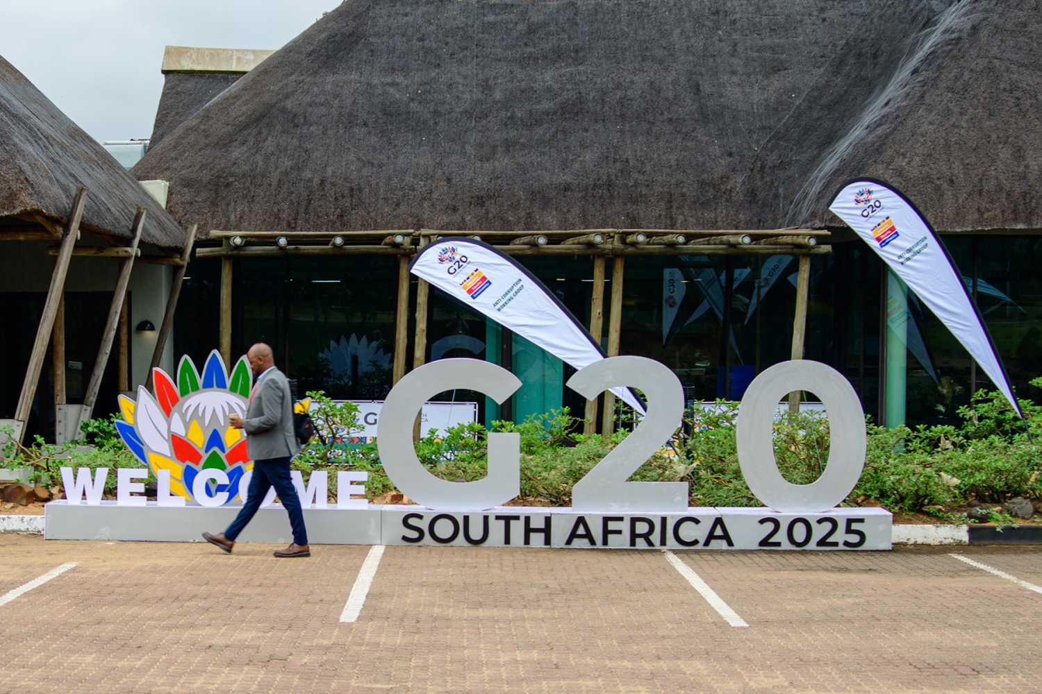 A man walks past a sign reading "G20 South Africa 2025."