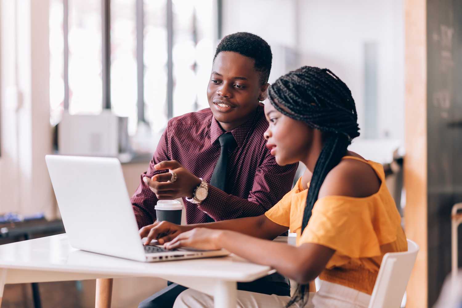 Young people work together at a laptop