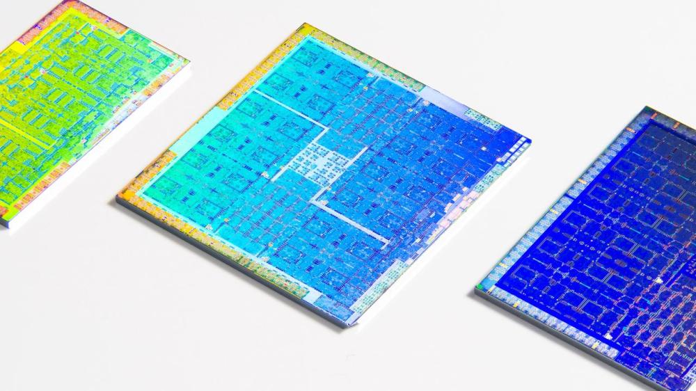 Three colorful GPUs with their packaging cleanly removed laying on a white surface