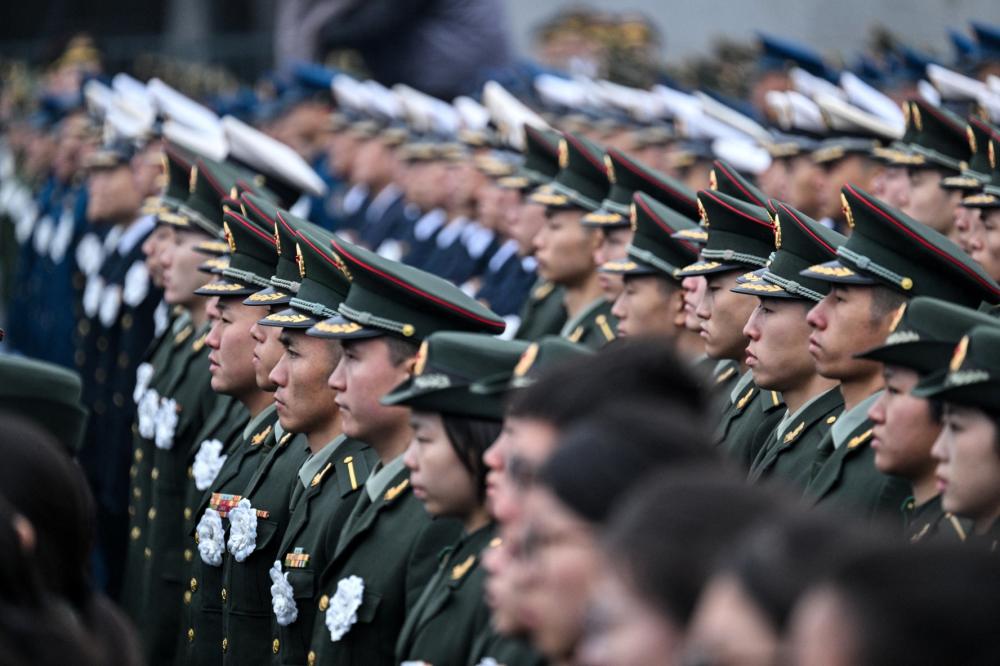 Chinese People's Liberation Army members attend a ceremony to mark China's National Memorial Day for Nanjing Massacre Victims in Nanjing, in China's eastern Jiangsu province on December 13, 2025.