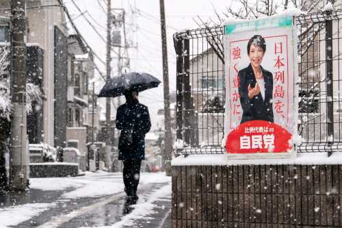 A pedestrian walks past an election poster bearing a photograph of Japanese Prime Minister and Liberal Democratic Party President Sanae Takaichi displayed near a polling station on February 08, 2026 in Tokyo, Japan.