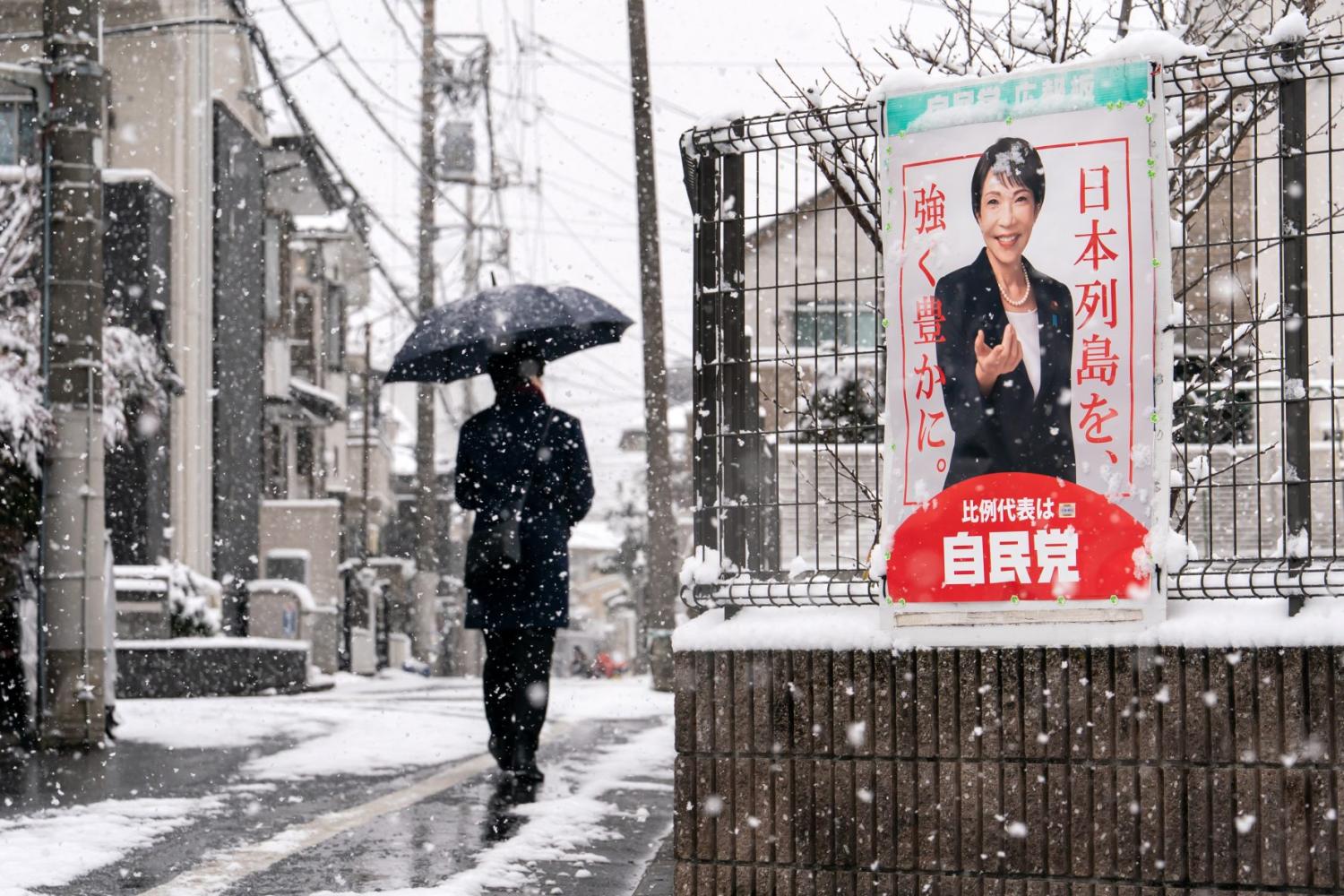 A pedestrian walks past an election poster bearing a photograph of Japanese Prime Minister and Liberal Democratic Party President Sanae Takaichi displayed near a polling station on February 08, 2026 in Tokyo, Japan.