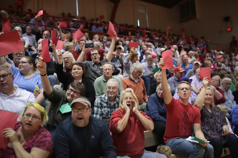 People hold up red pieces of paper to voice disagreement as Congressman Rod Blum (R-Iowa) speaks to his constituents during a town hall meeting on May 8, 2017 in Dubuque, Iowa.