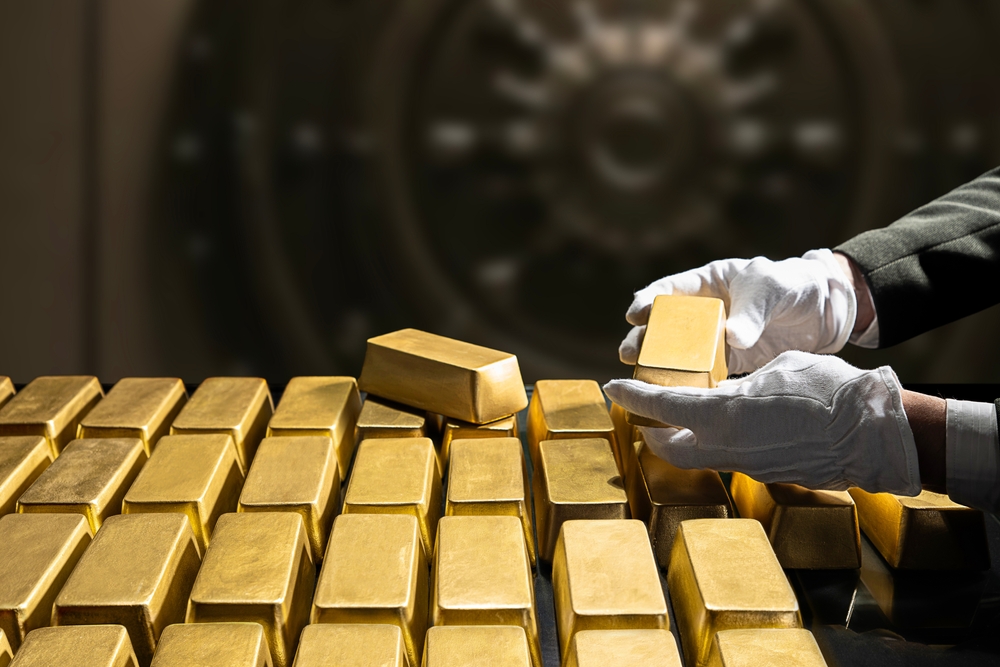 Banker's hands in white gloves, bank vault manager holding a gold bar, national gold reserv holdings concept. Savings and investments, business and finance