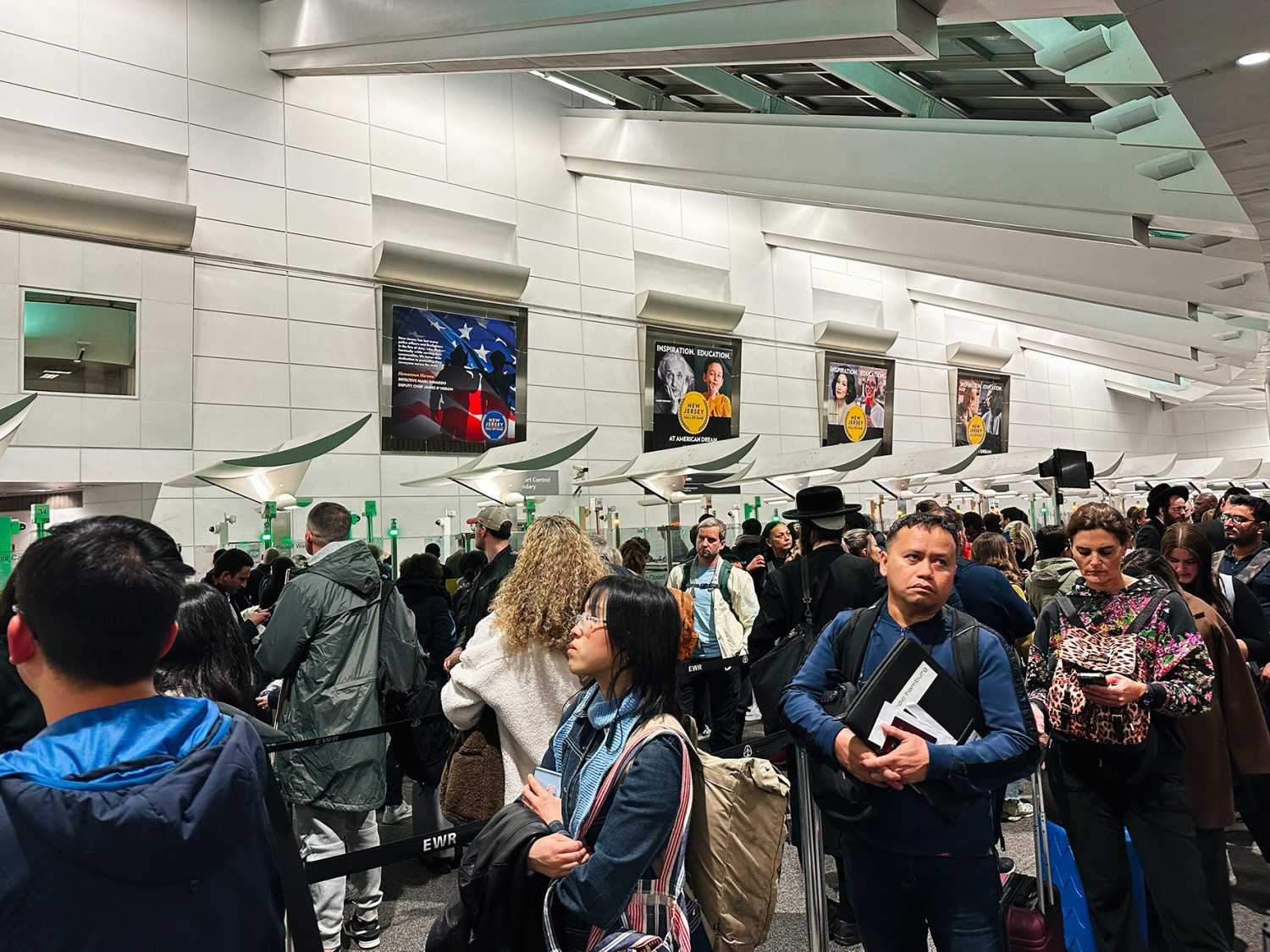 Newark, New Jersey, USA - April 01, 2025: Diverse group of passengers queuing in an airport customs area in Newark, New Jersey.