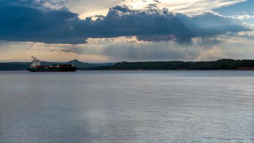 Canakkale, Turkey, November 12,2023: Cargo ship on the Dardanelles strait against evening sunset sky.