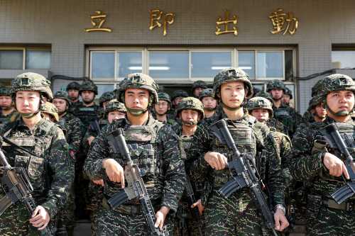 Taiwanese soldiers pose for a photo in front of inscriptions reading "immediate action" as Taiwan's President Lai Ching-te visits the troops taking part in the Rapid Response Exercise at the Songshan military airbase in Taipei on March 21, 2025.