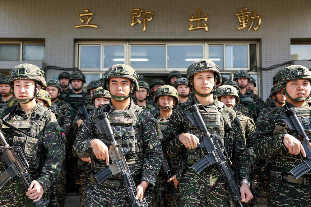 Taiwanese soldiers pose for a photo in front of inscriptions reading "immediate action" as Taiwan's President Lai Ching-te visits the troops taking part in the Rapid Response Exercise at the Songshan military airbase in Taipei on March 21, 2025.