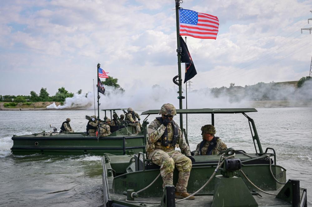 US soldiers operate pusher vessels to be used for assembly and operate a transportation barge across Danube river during SABER GUARDIAN 25 military exercise in Frecatei, eastern Romania on June 13, 2025.