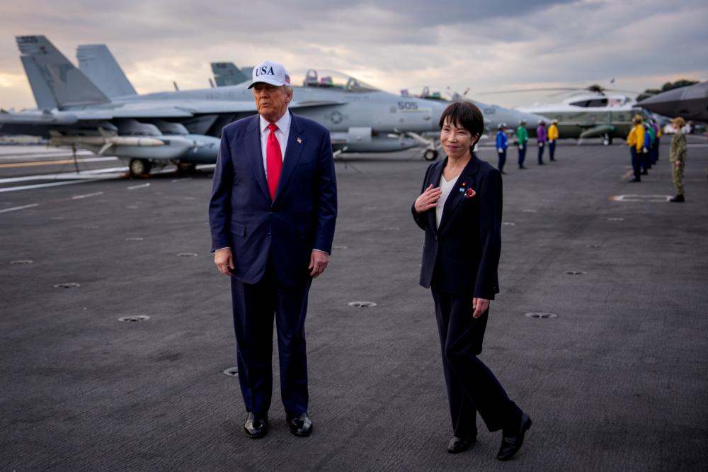 Japanese Prime Minister Sanae Takaichi reacts to a compliment by U.S. President Donald Trump as they arrive aboard USS George Washington at Fleet Activities Yokosuka on October 28, 2025 in Yokosuka, Japan.