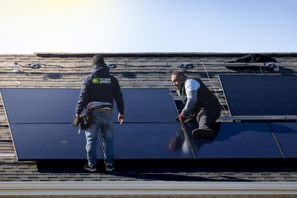A team of solar panel installers work to install a new solar panel array before the Federal Tax Credit Expires.