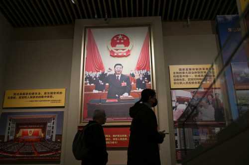 Visitors walk past portraits of China's President Xi Jinping at the Museum of the Communist Party of China in Beijing on March 1, 2026, ahead of the opening of the annual session of the National People's Congress (NPC).