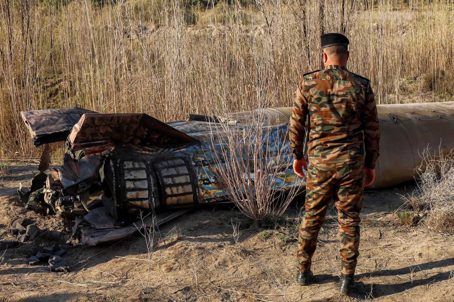 Members and officers from the Iraqi Interior Ministry's Explosives Directorate inspect the fuel tank of a rocket that landed in a rural village in the Siyahi area, near the city of Hillah in the central Babil province, Iraq, March 1, 2026.