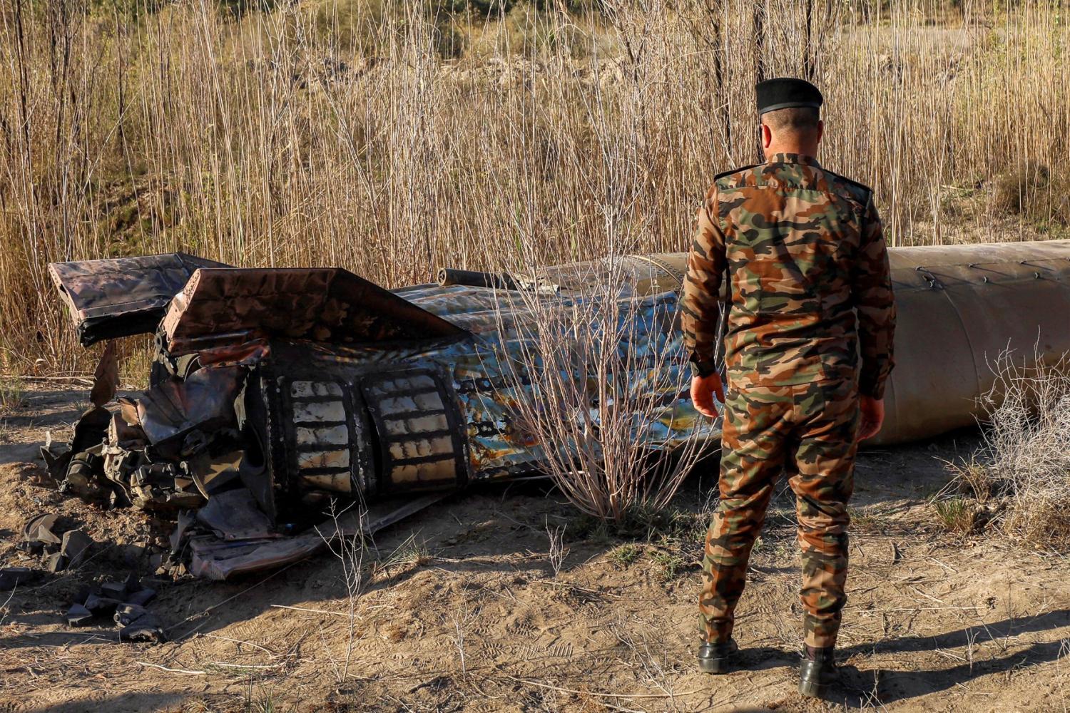 Members and officers from the Iraqi Interior Ministry's Explosives Directorate inspect the fuel tank of a rocket that landed in a rural village in the Siyahi area, near the city of Hillah in the central Babil province, Iraq, March 1, 2026.