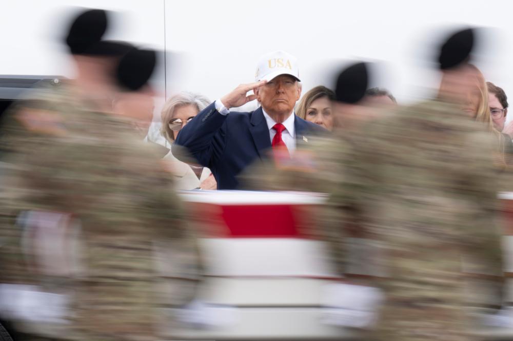 U.S. President Donald Trump salutes as a U.S. Army carry team moves a flag-draped transfer case containing the remains of Sgt. 1st Class Nicole M. Amor at Dover Air Force Base on March 07, 2026 in Dover, Delaware.