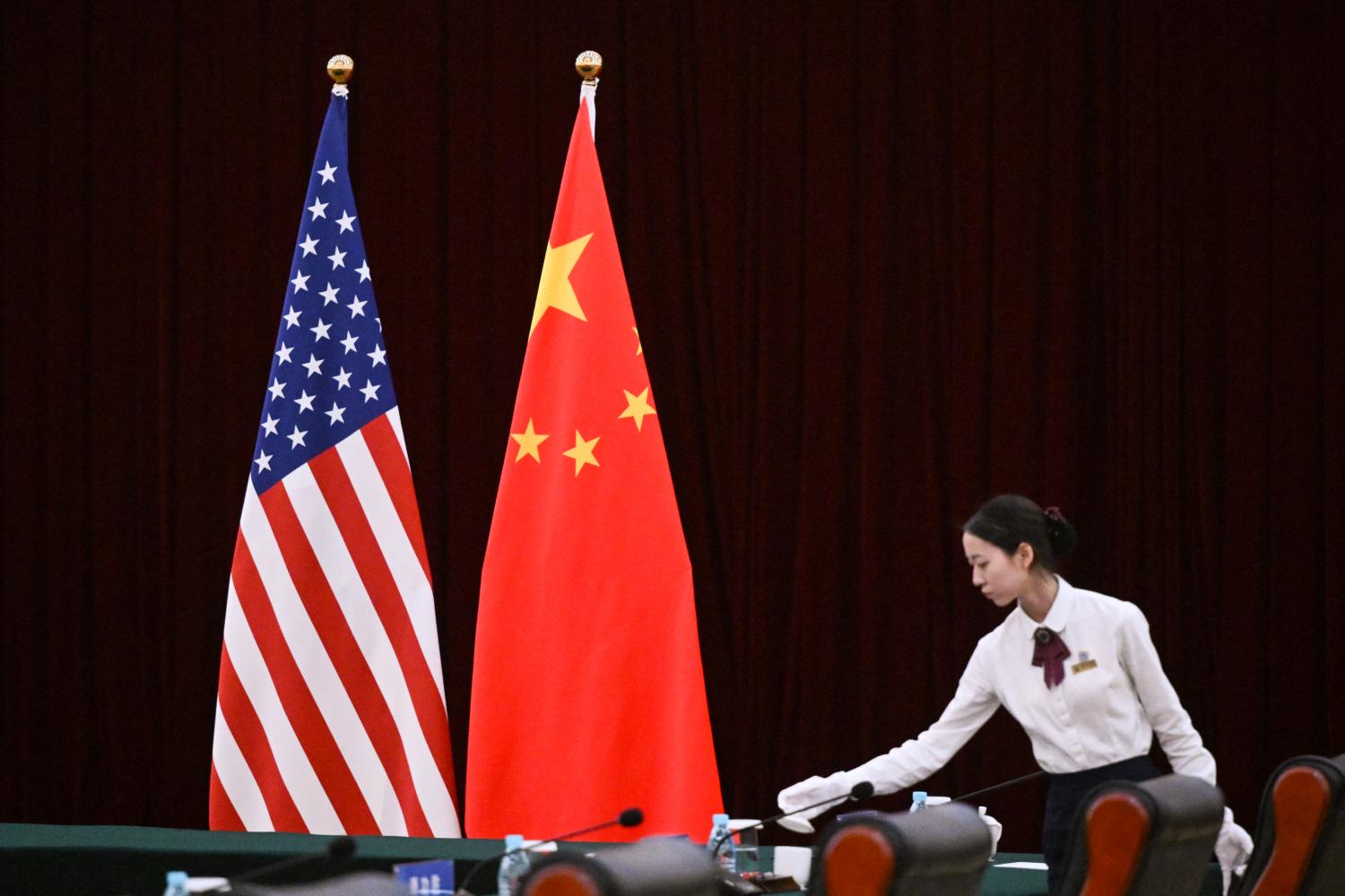US flag, China flag, person arranging the table.