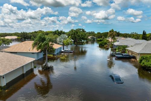 Flooded Florida street with stuck car after hurricane Debby rainfall surrounded with water. Consequences of natural disaster